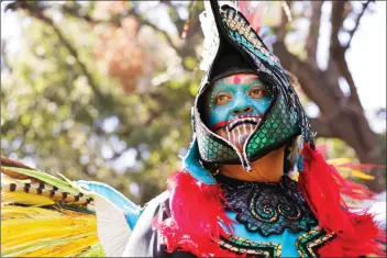  ?? Nikolas Samuels/The Signal (See additional photos at signalscv.com) ?? (Above) Adolfo Arteaga of the Aztec tribe stands in full regalia during the 24th annual Hart of the West PowWow and Native American Craft Fair At William S. Hart Regional Park in Newhall on Saturday. (Below) Samuel Two Crows Saldana, right, kneels with...