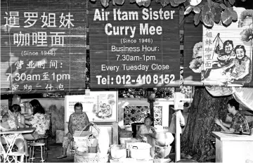  ??  ?? Lim Kooi Lye (third left) and Lim Kooi Heang (second right) selling curry mee and fried bee hoon, making the business significan­t in their family tradition.