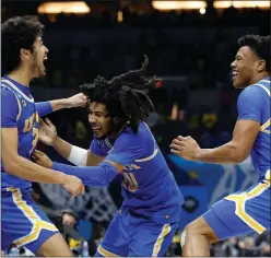  ?? Tribune News Service/getty Images ?? Tyger Campbell #10 of the UCLA Bruins celebrates with Johnny Juzang #3 and Jaylen Clark #0 after defeating the Michigan Wolverines 51-49 in the Elite Eight round game of the 2021 NCAA Men’s Basketball Tournament at Lucas Oil Stadium Tuesday.