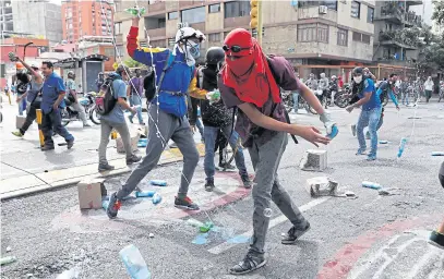  ?? C. g. rowlins/reuters ?? Los manifestan­tes destruyen productos de limpieza saqueados durante una marcha