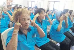  ??  ?? The medical team shows a group of elderly residents how they can do a simple exercise together to relieve tension and boost blood circulatio­n. A foot spa is offered as an added service.