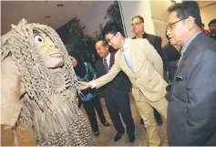  ??  ?? Tunku Zain (second right) reaches out to feel a strand of ‘hair’ on a Mah Meri mask while Baharudin (right) and Sidek (third right) look on.