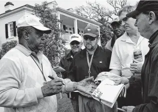  ?? Associated Press file photo ?? Lee Elder signs autographs for patrons at the 2008 Masters golf tournament in Augusta, Ga. Elder broke down racial barriers as the first Black golfer to play in the Masters.