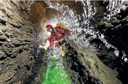  ?? PHOTO: NEIL SILVERWOOD ?? Neil Warrington places fluorescei­n dye into the ‘‘Far and Away’’ cave system, proving that Bulmer and the Blue Creek Resurgence connect.