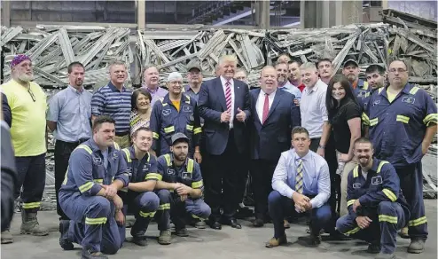  ?? JEFF SWENSEN / GETTY IMAGES ?? Then-Republican presidenti­al candidate Donald Trump gathers with workers in Monessen, Penn., last June. Nearly 1,000 Democrats in the town switched sides in the election and voted for Trump.