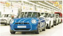  ?? JOE GIDDENS/PA ?? Minis stand in a row Monday at a plant in Oxford, England. German automaker BMW got funding from the UK to build EVs there and pledged to invest $751 million.