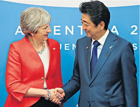  ??  ?? Shinzo Abe greets Theresa May at the G20 summit in Buenos Aires, Argentina, amid concerns over how Japanese companies, notably car makers, will cope with trade barriers