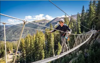  ?? NATHAN BURTON/Taos News ?? Via Ferrata guide Nano Lucero crosses a 100-foot sky bridge suspended 50 feet in the air Thursday (Sept. 1) at Taos Ski Valley.