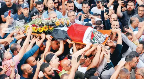  ?? Photo: Xinhua ?? Mourners carry the body of Al Jazeera journalist Shireen Abu Akleh in the West Bank city of Ramallah. Abu Akleh was killed in the West Bank on Wednesday.