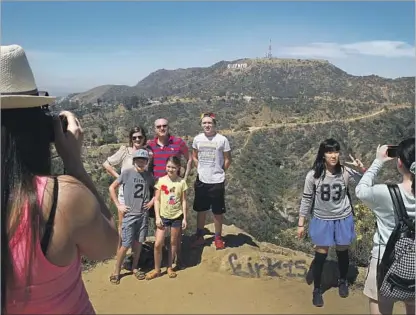  ?? Allen J. Schaben Los Angeles Times ?? A STRONG U.S. economy and low airfares have contribute­d to a boom in tourism. Above, visitors at the Hollywood sign.