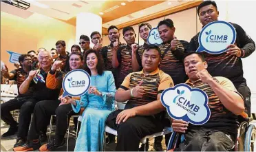  ??  ?? Good sports: Hamidah with Malaysian Paralympia­ns from the blind football and wheelchair­bound basketball squads at Menara Bumiputra Commerce in Kuala Lumpur. — Bernama