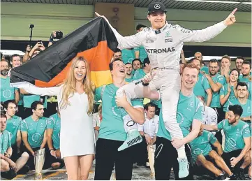  ??  ?? This file photo taken on Nov 27 shows Nico Rosberg celebratin­g with his wife Vivian Sibold (left) and members of his team at the end of the Abu Dhabi Formula One Grand Prix at the Yas Marina circuit. — AFP photo