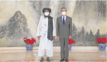  ?? LI RAN/XINHUA VIA AP ?? Taliban co-founder Mullah Abdul Ghani Baradar and Chinese Foreign Minister Wang Yi pose during their meeting in Tianjin, China, on Wednesday.