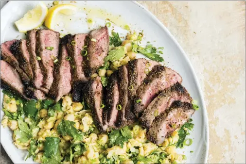  ?? MILK STREET VIA AP ?? This image released by Milk Street shows a recipe for Spice-Crusted Steak with a side of partially mashed chickpeas.