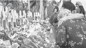  ??  ?? People visit a makeshift memorial in front of Marjory Stoneman Douglas High School in Parkland, Fla., on Tuesday. CRISTOBAL HERRERA/EPA-EFE