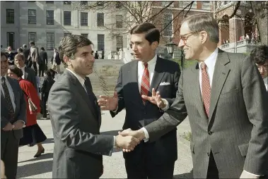  ?? JIM SHEA — THE ASSOCIATED PRESS FILE ?? Massachuse­tts Governor Michael Dukakis, left, shakes the hands of former Delaware Governor Pierre Du Pont, right as former Virginia Governor Charles S. Robb looks on April 27, 1987after they attended the Jobs for Bay State Grads program in Boston.