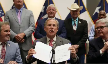  ?? Tuesday. Photograph: LM Otero/AP ?? Governor Greg Abbott shows off his signature after signing Senate Bill 1, also known as the election integrity bill, into law in Tyler, Texas, on