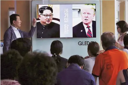  ?? Associated Press ?? People watch a TV screen showing file footage of Donald Trump and Kim Jong Un during a news programme at the Seoul Railway Station in Seoul on Tuesday.