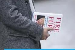  ??  ?? WASHINGTON: A man holds a copy of the book ‘Fire and Fury: Inside the Trump White House’ by Michael Wolff after buying it at a bookstore in Washington, DC.— AFP