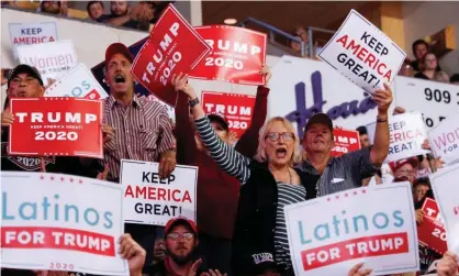  ?? Photograph: Tom Brenner/ Reuters ?? Members of the audience look on Trump delivers remarks at a rally in Rio Rancho, New Mexico, on Monday.