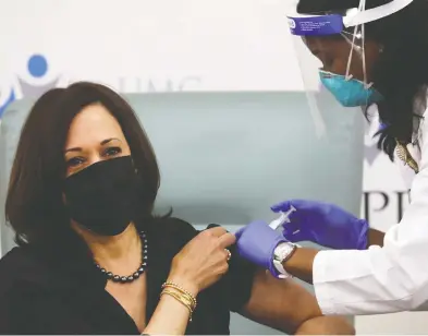 ?? LEAH MILLIS / REUTERS ?? Vice-president-elect Kamala Harris rolls up her sleeve for a dose of the Moderna's vaccine live on television Tuesday.