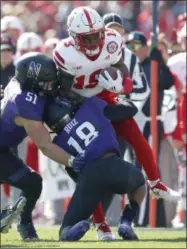  ?? JIM YOUNG — THE ASSOCIATED PRESS ?? Nebraska’s Mike Williams (19) is tackled by Northweste­rn’s Blake Gallagher (51) and Northweste­rn’s Cameron Ruiz during the first half of an NCAA college football game Saturday, Oct. 13, 2018, in Evanston, Ill.