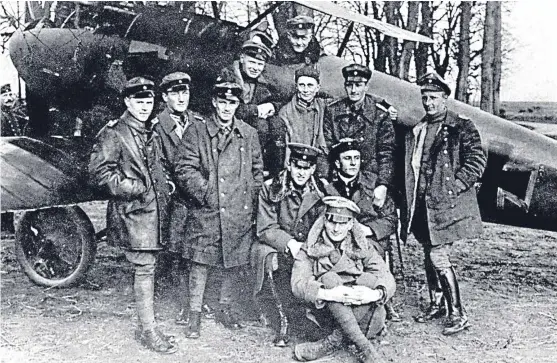  ??  ?? Red Baron Manfred von Richthofen, sitting in the cockpit of his aircraft, and his squadron pose for a photograph during the First World War.