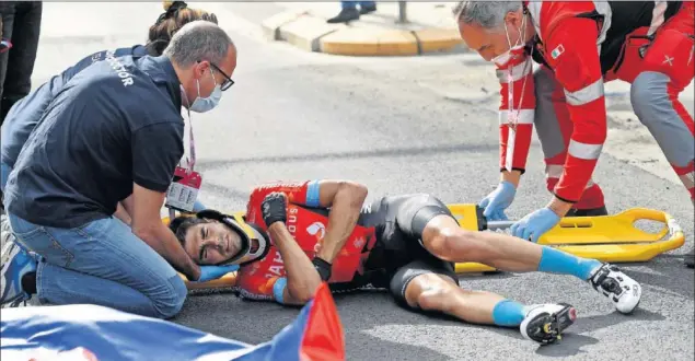  ??  ?? Mikel Landa, con collarín y sujetado por los médicos del Giro antes de ser evacuado en ambulancia al hospital de Riccione, después de que una caída le obligara a abandonar.