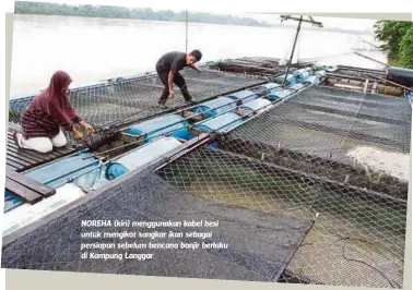  ??  ?? NOREHA (kiri) menggunaka­n kabel besi untuk mengikat sangkar ikan sebagai persiapan sebelum bencana banjir berlaku di Kampung Langgar.