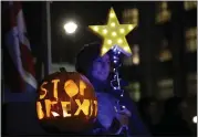  ?? MATT DUNHAM — THE ASSOCIATED PRESS ?? A pumpkin with the words “Stop Brexit” carved in it stands next to a protester near the Houses of Parliament in London on Tuesday.