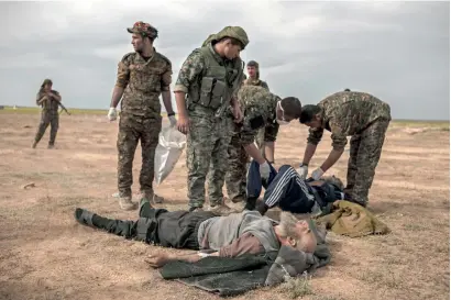  ?? AFP ?? Soldeirs of the US-backed Syrian forces attend to wounded civilians in Syria’s eastern Deir El Zour province. —