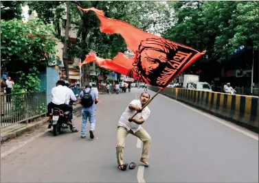  ?? REUTERS ?? A man waves a flag as he blocks a road during a protest organised by the Maratha community to press their demands for reservatio­n in government jobs and college seats, in Mumbai on Wednesday.