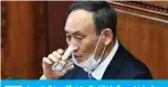  ?? — AFP ?? TOKYO: Japan’s Prime Minister Yoshihide Suga drinks from a glass of water during his policy speech at the opening session of the lower house of parliament in Tokyo.
