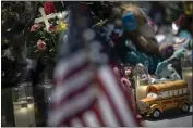  ?? WONG MAYE-E — THE ASSOCIATED PRESS ?? A toy yellow school bus is placed in front of a cross to honor Rojelio Torres, one of the children killed during the mass shooting in Robb Elementary School in Uvalde, Texas, while a U.S. flag is seen in the foreground, on Sunday.