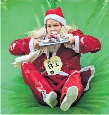  ??  ?? A competitor tackles the obstacle course at yesterday’s Great Christmas Pudding Race in Covent Garden, London, for Cancer Research UK.