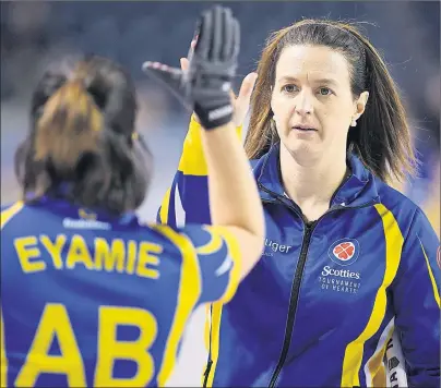  ?? THE CANADIAN PRESS/SEAN KILPATRICK ?? Alberta alternate Heather Nedohin gives third Lisa Eyamie a high five after a win over Saskatchew­an during the Scotties Tournament of Hearts in St. Catharines, Ont., on Tuesday.