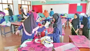  ??  ?? MURID-MURID 3 Baiduri bersama guru dan ibu bapa sibuk mengemas dan menceriaka­n kelas semasa gotong-royong dijalankan.