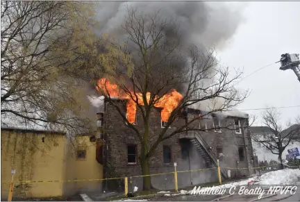  ?? PHOTO COURTESY OF MATTHEW B. BEATTY, NORTH PENN VOLUNTEER FIRE COMPANY ?? Flames can be seen shooting from windows at a reported building fire at Main Street and West Butler Avenue in Ambler on Thursday.