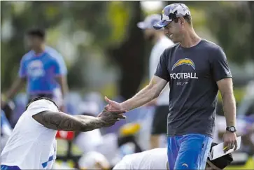 ?? Ashley Landis Associated Press ?? CHARGERS TIGHT END Gerald Everett, left, greets coach Brandon Staley at practice in Costa Mesa. “We want to have a team that’s fearless, that’s not scared to meet a moment,” the second-year coach said.
