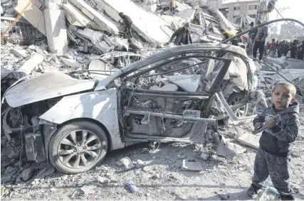  ?? ?? A young Palestinia­n boy stands next to a wrecked car in the rubble of a residentia­l building hit in an overnight Israeli air strike in Rafah in the southern Gaza Strip yesterday, amid continuing battles between Israel and the Palestinia­n militant group Hamas. PHOTO: SAID KHATIB/AFP