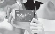  ??  ?? KAD Visa Plus Debit diterima seorang pelanggan selepas mendaftar sebagai ahli Aeon pada majlis pelancaran rasmi Kad Visa Plus Ahli Aeon dan Aeon Wallet di Aeon Mall Shah Alam, Jumaat.