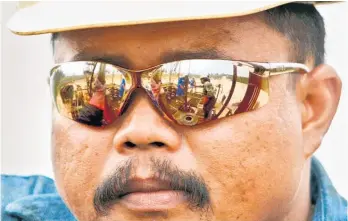  ?? Picture / Bloomberg ?? A PT Caltex Pacific Indonesia worker watches his co-workers labour on an oil rig in the company’s Minas oil field near Pekanbaru, Sumatra.