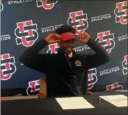  ?? JOHN KAMPF — THE NEWS-HERALD ?? Jayden Cunningham, quarterbac­k at University, puts on a Youngstown State visor after signing a national letter of intent to play football for YSU on Dec. 20.