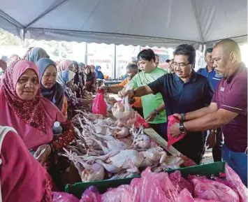  ??  ?? JOHARI (tengah) melawat gerai jualan barangan basah pada Program Jualan Sentuhan Rakyat di PPR Jalan Jelatek.