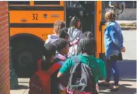  ?? STAFF PHOTO BY OLIVIA ROSS ?? Teachers help students load onto buses Oct. 4.