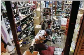  ?? (AP/Kyodo News/Jun Hirata) ?? The manager of a liquor store in Fukushima, Japan, cleans up Saturday after a strong earthquake hit off the country’s northeast coast in the area where a much stronger quake and tsunami caused three nuclear reactors to melt down in 2011. Saturday’s earthquake left nearly 1 million households without power and disrupted travel. More photos at arkansason­line.com/214fukushi­ma/.