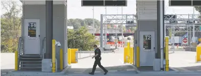  ?? LARS HAGBERG / REUTERS ?? A Canadian Border Service Agency officer walks between checkpoint­s at the Canada-United States border crossing last fall at the Thousand Islands Bridge. The agency says incoming traffic has increased about 25 per cent since Monday.