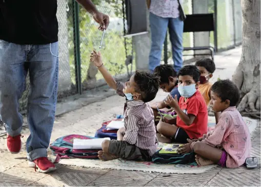  ?? MANISH SWARUP AP ?? Veena and Virendra Gupta conduct free classes for children on a sidewalk in New Delhi. India’s stringent lockdown to curb the spread of COVID-19 shuttered schools across the country in late March. Most remain closed.