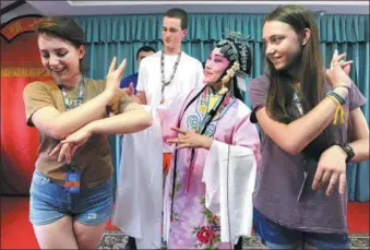  ?? HANG XINGWEI / FOR CHINA DAILY ?? Middle school students from the states of Pennsylvan­ia and Maine in the United States get a lesson in Kunqu Opera in Suzhou, Jiangsu province, on Tuesday, as part of their summer holiday.
