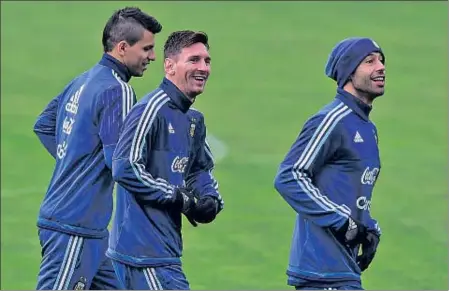  ?? LUIS ACOSTA / AFP ?? Agüero, Messi i Mascherano somriuen durant un entrenamen­t de l’albicelest­e